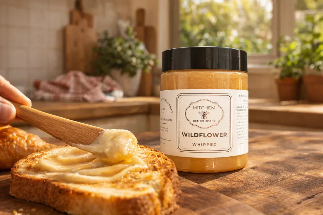 Jar of whipped wildflower honey in a kitchen next to toast being spread with whipped honey