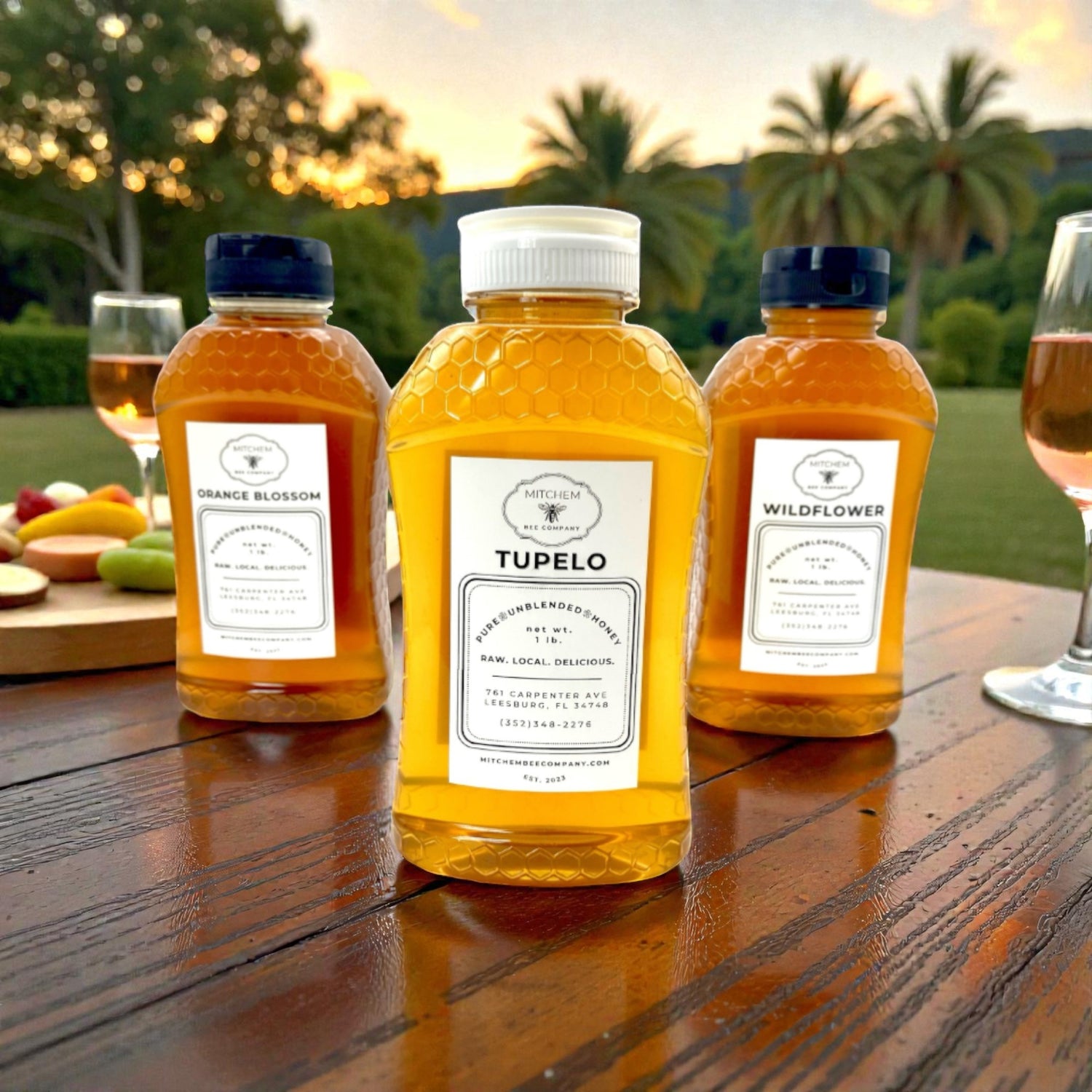 Three bottles of Tupelo honey on a wooden table with a scenic background