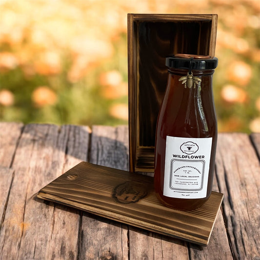 Bottle of Wildflower honey in a wooden box on a wooden surface with a blurred natural background